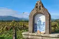 Heiligen Jakobus Schrein, der den Pilgern auf dem Jakobsweg den Weg weist, umgeben von Weinbergen und mit Blick auf die Berge.
