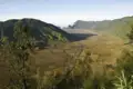 Panoramablick auf ein Tal inmitten grüner Hügel.