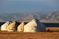 Traditionelle mongolische Jurtenbehausungen in einer weiten Landschaft.