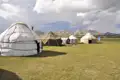 Jurtenunterkünfte in einer Bergregion, möglicherweise Teil einer kulturellen Reiseerfahrung.