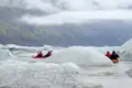 Kajakfahrer navigieren durch eisbedeckte Gewässer.