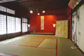 Traditioneller japanischer Raum mit roten Wänden, Tatami-Matten und Schiebetüren.