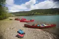 Rote Kanus am Ufer eines Flusses, vorbereitet für eine Paddeltour.