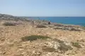 Wanderer auf einem felsigen Küstenpfad mit Blick auf das Meer.