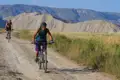 Radfahrer auf einem unbefestigten Weg in bergigem Gelände.