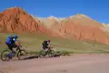 Zwei Mountainbiker auf einer Radtour durch eine Landschaft mit roten Felsformationen.