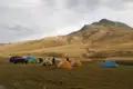 Campingplatz in den Bergen mit Zelten und einem Fahrzeug.