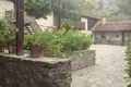 Gepflasterter Innenhof eines steinernen Gebäudes mit Pflanzen und Bäumen.