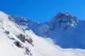 Verschneite Berglandschaft unter blauem Himmel.
