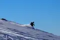 Skifahrer auf der Abfahrt im Schnee.
