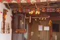 Traditionell dekorierter Eingang des Hanivjeter Restaurants in Prizren mit Teppichen, Beleuchtung und lokalen Elementen.