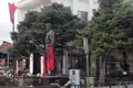 Statue eines Mannes in Uniform mit albanischen Flaggen.