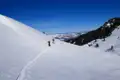 Zwei Personen auf Skitour im Aufstieg eines verschneiten Hangs.