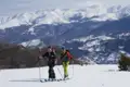 Zwei Skitourengeher auf einer Tour in den verschneiten Bergen.