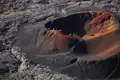 Wanderer erkunden den Rand eines Vulkankraters mit unterschiedlichen Farbschattierungen im Gestein.