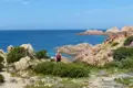 Wanderer auf einem Küstenpfad mit Blick auf das Meer und die Felsen.