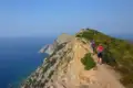 Wanderer auf einem Küstenpfad mit Meerblick.