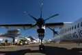 Flugzeug auf dem Flughafen vor einer Bergkulisse.