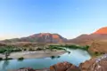 Panoramablick auf einen Fluss, der sich durch eine bergige Landschaft schlängelt.