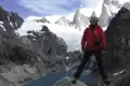 Wanderer vor Bergkulisse mit Gletscher und See.