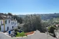 Blick auf eine hügelige Landschaft mit weißen Häusern und Ziegeldächern.