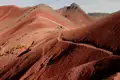 Wanderer auf einem Bergpfad mit roter Erde.