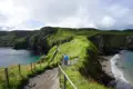 Wanderweg auf einer grünen Klippe entlang der Küste.