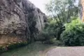 Flusslandschaft mit Felswänden und Vegetation.