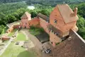 Luftbild einer Backsteinburg mit Innenhof, Besuchern und umliegender Landschaft.