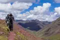 Zwei Wanderer auf einem Bergpfad mit Blick auf die umliegende Berglandschaft.