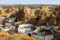 Traditionelle Höhlenwohnungen in Guadix, Spanien, mit der Stadt und der Burg im Hintergrund.