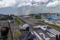 Flugzeug auf der Landebahn des Flughafens Lukla, umgeben von Bergen.