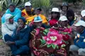 Gruppe von Menschen, die in Decken und Hüten versammelt sind.