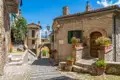 Traditionelle Steinhäuser und Kopfsteinpflastergasse in einem italienischen Dorf.