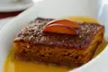 Kuchenstück mit Pflaumen und Soße.