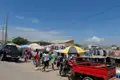 Lokaler Markt mit Händlern, die Waren unter Sonnenschirmen verkaufen.
