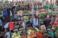 Händler verkaufen frisches Obst und Gemüse auf einem belebten Markt.