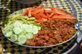 Gemüseplatte mit Gurken, Zucchini, Karotten und einem Paprika-Tomaten-Gericht.