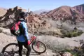 Mountainbikerin mit Blick auf historische Stätte im Tal während einer Radtour.