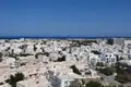 Panoramablick auf die Stadt mit weißen Gebäuden und dem blauen Meer im Hintergrund.