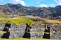 Detailansicht der Inka-Steinmauern mit den Anden im Hintergrund.