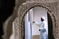 Mann in traditioneller Kleidung in einem verzierten Torbogen.