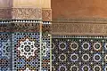 Detailansicht der kunstvollen Mosaikfliesen und der arabischen Kalligrafie, die die Wände schmücken.