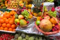 Auslage von verschiedenen Früchten auf einem Marktstand.  Körbe gefüllt mit einer bunten Mischung aus tropischen und regionalen Früchten.