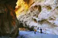 Wanderer durchqueren eine Schlucht mit einem Fluss.