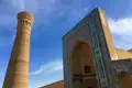 Minarett und kunstvoll verzierter Eingang eines historischen Gebäudes.