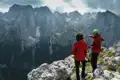 Zwei Wanderer auf einem Berggipfel mit Blick auf das Tal.