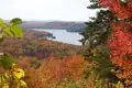 Herbstliche Szene mit Blick auf einen See und bunte Bäume.