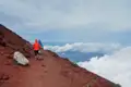 Wanderer auf einem Bergpfad über den Wolken.