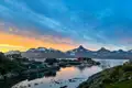 Sonnenuntergang über einem Küstenort und schneebedeckten Bergen in Grönland.